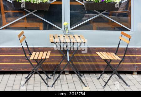 Area caffè all'aperto, mobili da giardino, tavolo pieghevole e sedie sul marciapiede. Foto Stock