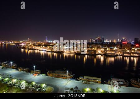 Vista notturna del souk dell'oro e del torrente con Burj Khalifa che torreggia in lontananza. Dubai, Emirati Arabi Uniti, 12.12.2018 Foto Stock