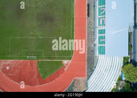 Vista aerea del campo da calcio verde vuoto con pista da corsa vista dallo stadio vuoto dall'alto Foto Stock