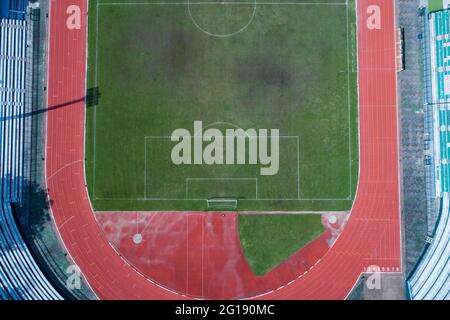 Vista aerea del campo da calcio verde vuoto con pista da corsa vista dallo stadio vuoto dall'alto Foto Stock