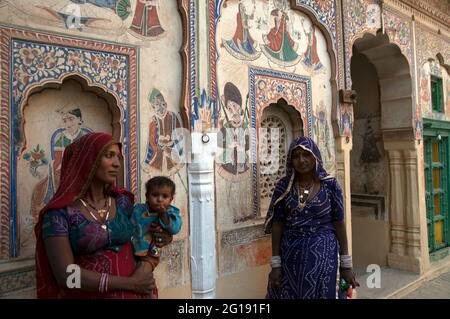 Due Signore locali con un bambino all'interno del cortile di un haveli a Mandawa a Shekhawati, Rajasthan Foto Stock