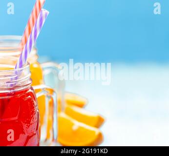 Primo piano due tazze con succo d'arancia e fragole su sfondo blu Foto Stock