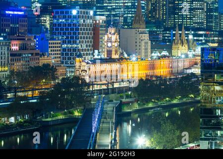 Stazione di Flinders Street a Melbourne, Australia, vista di notte lungo il ponte Sandridge che attraversa il fiume Yarra. Foto Stock