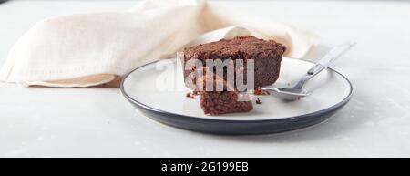Dessert di brownie al cioccolato sul piatto con tovagliolo. Concetto di panetteria e pasticceria. Foto Stock
