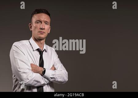 Uomo in camicia bianca e cravatta le braccia Foto Stock