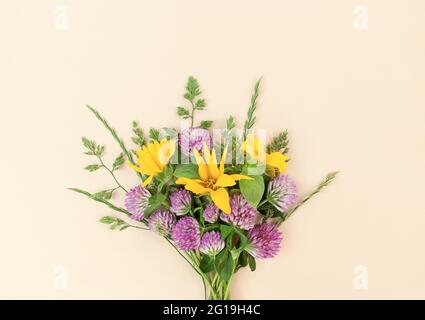 Bouquet da varietà di fiori selvatici su sfondo beige. Foto Stock