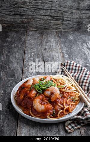 Mescolare i tagliatelle con i gamberi e le verdure su un tavolo di legno Foto Stock
