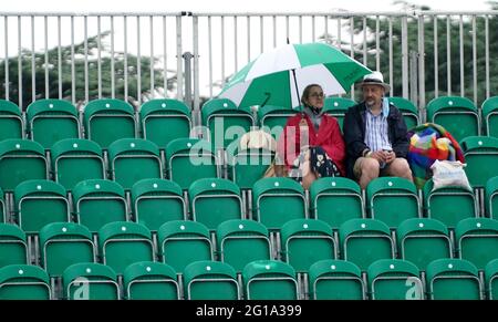 I fan si rifugiano sotto gli ombrelloni durante una pausa pioggia durante il secondo giorno del Viking Open al Nottingham Tennis Center. Data immagine: Domenica 6 giugno 2021. Foto Stock