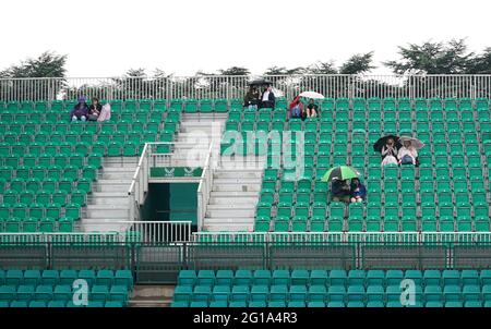 I fan si rifugiano sotto gli ombrelloni durante una pausa pioggia durante il secondo giorno del Viking Open al Nottingham Tennis Center. Data immagine: Domenica 6 giugno 2021. Foto Stock