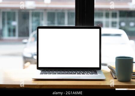 Bock up. Tavolo in legno con un computer portatile schermo vuoto e caffè sul tavolo in ufficio Foto Stock