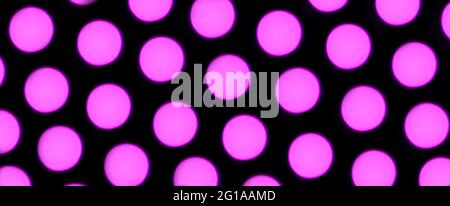 Bokeh luci di sfondo, un sacco di viola bokeh cerchi chiari allineati su solido sfondo nero, creativo idea idea foto. Banner. Foto Stock