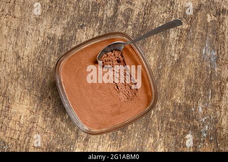 Mousse di cioccolato francese tradizionale in una ciotola e un cucchiaio sul vecchio sfondo di legno, vista dall'alto Foto Stock