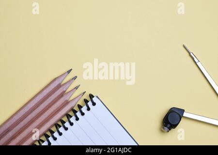 Disposizione piatta, vista dall'alto di matita, bussola e notebook a spirale. Ufficio, tavolo da lavoro Foto Stock