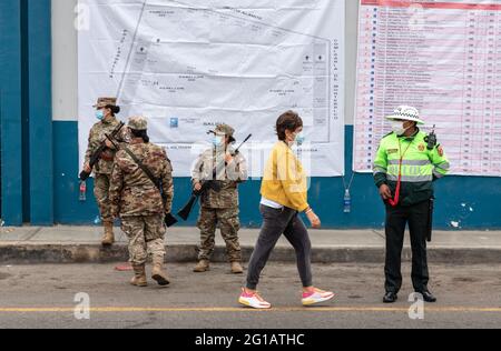 Giugno 2021 turno di votazioni per il Presidente del Perù. Donna peruviana di mezza età alla stazione di voto, mentre la polizia mascherata e le forze armate sono alla porta. Foto Stock