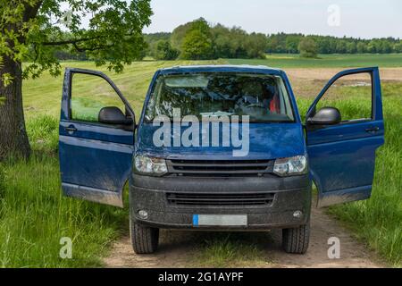 Grande pulmino blu sul sentiero in verde primavera fresca natura Foto Stock