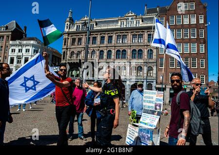 (NOTA PER I REDATTORI: L'immagine contiene profanità) UN dimostratore palestinese che tiene una bandiera e mostra un dito medio ad una bandiera di Israele durante una dimostrazione pro Palestina alla Piazza Dam ad Amsterdam. Durante una manifestazione pro Palestina organizzata dalla comunità palestinese nei Paesi Bassi in Piazza Dam ad Amsterdam, si sono verificati conflitti tra palestinesi e alcuni israeliani che hanno manifestato nello stesso momento e nello stesso luogo. Alcuni di loro sono stati feriti durante le lotte e gli arresti sono stati effettuati dalla polizia olandese. Dopo di che, la manifestazione Pro Palestine ha proseguito senza alcun olio Foto Stock