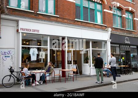 Persone clienti social distancing tavoli seduti fuori Prufrock Coffee shop durante la pandemia Covid in Exmouth Market Londra Inghilterra Regno Unito KATHY DEWITT Foto Stock