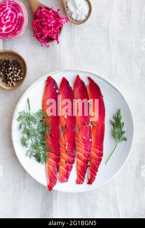 Da sopra gravlax con peppercorne miste e sprigg di aneto fresco su piatto su sfondo chiaro Foto Stock