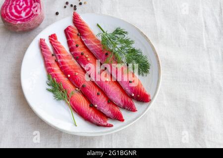 Da sopra gravlax con peppercorne miste e sprigg di aneto fresco su piatto su sfondo chiaro Foto Stock
