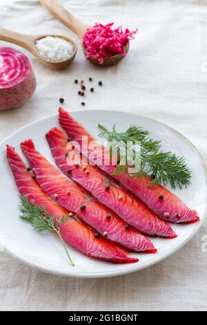 Da sopra gravlax con peppercorne miste e sprigg di aneto fresco su piatto su sfondo chiaro Foto Stock