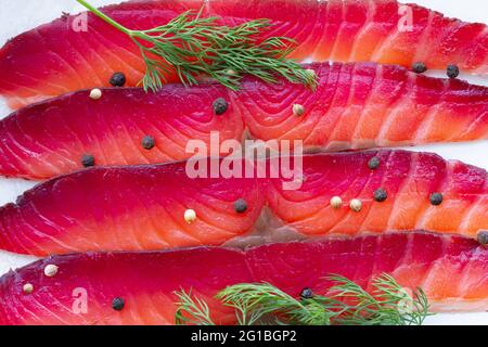 Da sopra gravlax con peppercorne miste e sprigg di aneto fresco su piatto su sfondo chiaro Foto Stock
