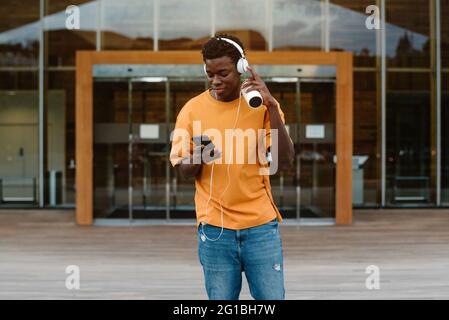 Americano africano maschio barbuto con dreadlocks holding Bandiera della Giamaica vicino a tree Foto Stock