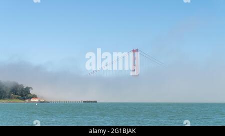 San Francisco, USA - Agosto 2019: Golden Gate Bridge sotto nebbia, con una torre visibile. Il Golden Gate Bridge è un ponte sospeso che attraversa il Gol Foto Stock