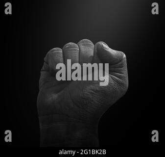 Black Hand Fist Design con luce spot su sfondo scuro. Modern Black Lives Matter concetto di sfondo Foto Stock
