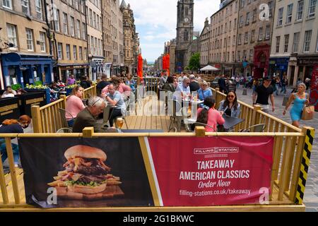 Edimburgo, Scozia, Regno Unito. 6 giugno 2021. Il caldo clima soleggiato ha attirato molti clienti verso caffè e ristoranti all'aperto nella città vecchia di Edimburgo oggi. PIC; i commensali siedono sulla terrazza all'aperto sul Royal Mile. Iain Masterton/Alamy Live News Foto Stock