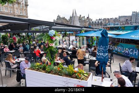 Edimburgo, Scozia, Regno Unito. 6 giugno 2021. Il caldo clima soleggiato ha attirato molti clienti verso caffè e ristoranti all'aperto nella città vecchia di Edimburgo oggi. PIC; Busy birreria all'aperto su Princes Street. Iain Masterton/Alamy Live News Foto Stock