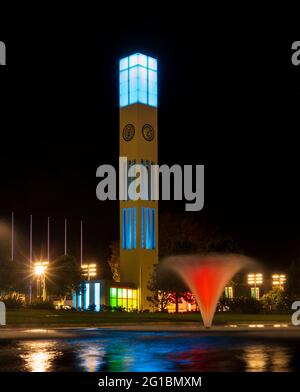 Palmerston North si illumina di notte con l'orologio principale nel centro della città dà uno spettacolo colorato. Foto Stock