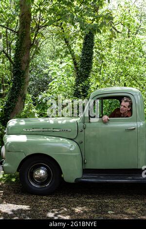 Uomo seduto all'interno del suo pick-up Ford F 1. Foto Stock