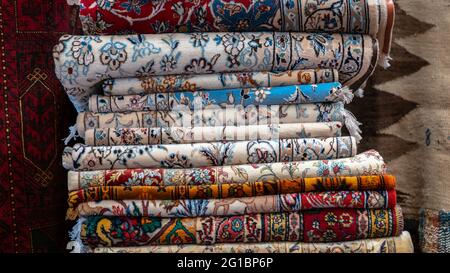Isfihan, Iran - Maggio 2019: Pila di tappeti e tappeti tradizionali iraniani in un negozio di tappeti Foto Stock