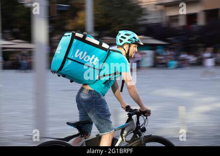 Belgrado, Serbia - 5 giugno 2021: Consegna Wolt servizio di corriere di cibo cavalcare una bicicletta sulla strada della città in una giornata di sole Foto Stock