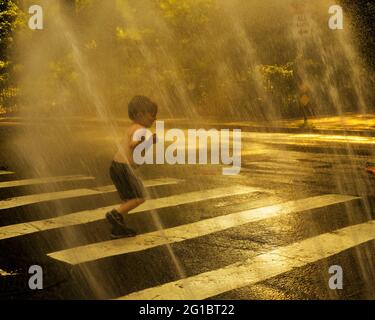 New York, New York, Stati Uniti. 6 Giugno 2021. I bambini si rinfrescarono nella tradizionale vita cittadina, attraverso un idrante a fuoco aperto, in una calda giornata estiva nell'Upper West Side di New York City. Le temperature hanno raggiunto i 90 gradi per il secondo giorno consecutivo. Credit: Debra L. Rothenberg/ZUMA Wire/Alamy Live News Foto Stock