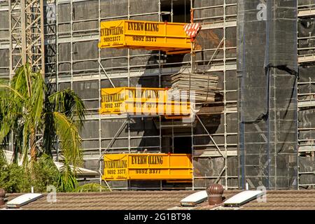 Gosford, NSW, Australia - 22 aprile 2021: Fotografia del progresso edilizio. Fornitura di materiale in legno mediante gru a torre per la costruzione di nuove abitazioni sociali a Foto Stock