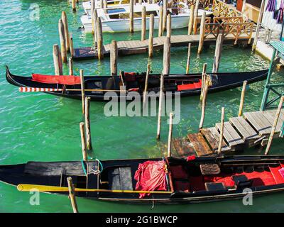 Molo con gondole a Venezia. Gondole ricoperte di teloni. Foto Stock