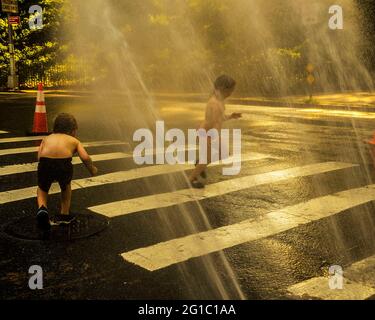 New York, New York, Stati Uniti. 6 Giugno 2021. I bambini si rinfrescarono nella tradizionale vita cittadina, attraverso un idrante a fuoco aperto, in una calda giornata estiva nell'Upper West Side di New York City. Le temperature hanno raggiunto i 90 gradi per il secondo giorno consecutivo. Credit: Debra L. Rothenberg/ZUMA Wire/Alamy Live News Foto Stock
