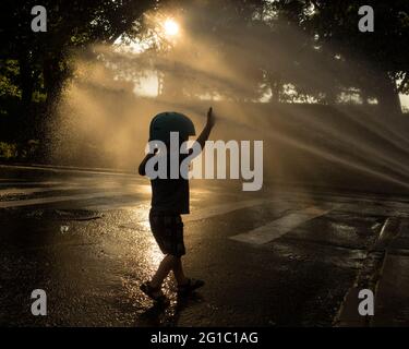 New York, New York, Stati Uniti. 6 Giugno 2021. I bambini si rinfrescarono nella tradizionale vita cittadina, attraverso un idrante a fuoco aperto, in una calda giornata estiva nell'Upper West Side di New York City. Le temperature hanno raggiunto i 90 gradi per il secondo giorno consecutivo. Credit: Debra L. Rothenberg/ZUMA Wire/Alamy Live News Foto Stock