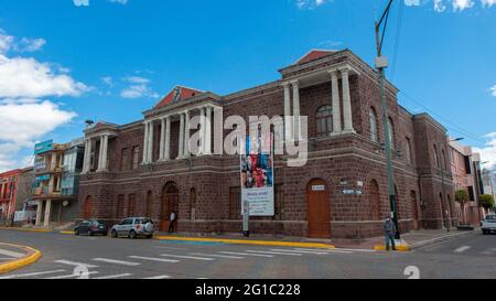 Salcedo, Cotopaxi / Ecuador - 5 giugno 2021: Persone che camminano di fronte al palazzo comunale nel centro della città di Salcedo in una giornata di sole Foto Stock