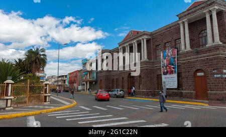 Salcedo, Cotopaxi / Ecuador - 5 giugno 2021: Persone che camminano di fronte al palazzo comunale nel centro della città di Salcedo in una giornata di sole Foto Stock