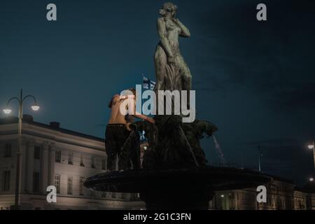 07.06.2021 HELSINKI, FINLANDIA. La Finlandia prende l'argento nel Campionato del mondo IIHF. Durante la celebrazione, una coppia si trova in cima alla fontana nel centro di Helsinki. Foto Stock