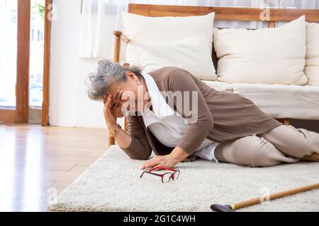 Ictus anziano, la donna anziana asiatica soffre di ictus e potente mal di testa o attacco cerebrale Foto Stock