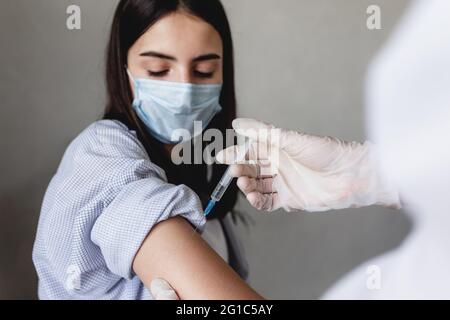 Il medico inietta il vaccino alla ragazza. Foto di alta qualità Foto Stock