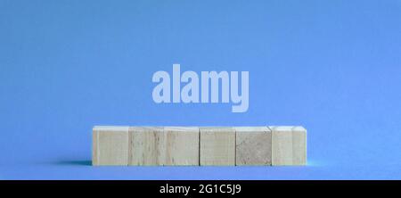 6 lettere vuote e blocchi di legno su tavolo con sfondo blu. Foto Stock