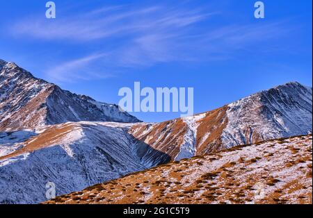 Maestose montagne con prati alpini adesi di ginepri contro a. cielo blu con nuvole Foto Stock