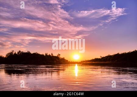 Atmosfera magica di una serata romantica; tramonto dorato sul fiume Foto Stock