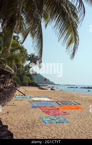 Grandi trapunte etniche colorate disposte sulla spiaggia di Cola (Khola) (conosciuta anche come spiaggia segreta), Canacona, Goa, India Foto Stock