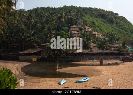 Donna che guada nella laguna di Cola (Khola) Beach (conosciuta anche come Secret Beach), Canacona, Goa, India Foto Stock