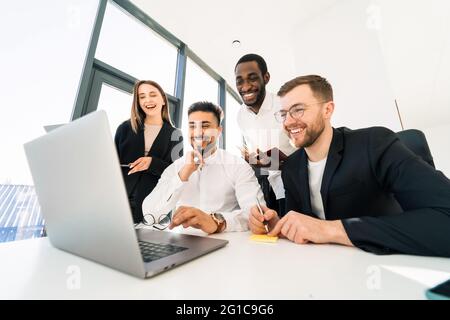 Un gruppo di professionisti IT multirazziali sta lavorando insieme a un notebook Foto Stock
